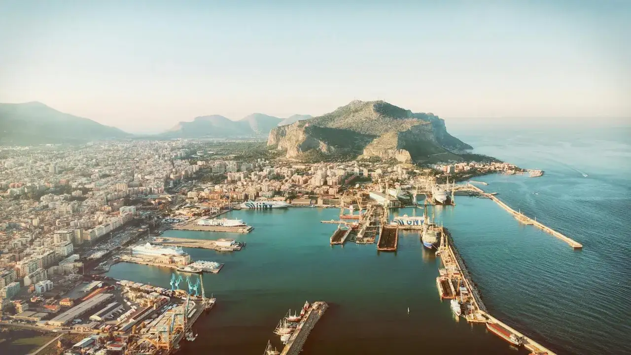 Piękna, słoneczna pogoda na Sycylii w maju. Widok na port i miasto z g&oacute;rami w tle.