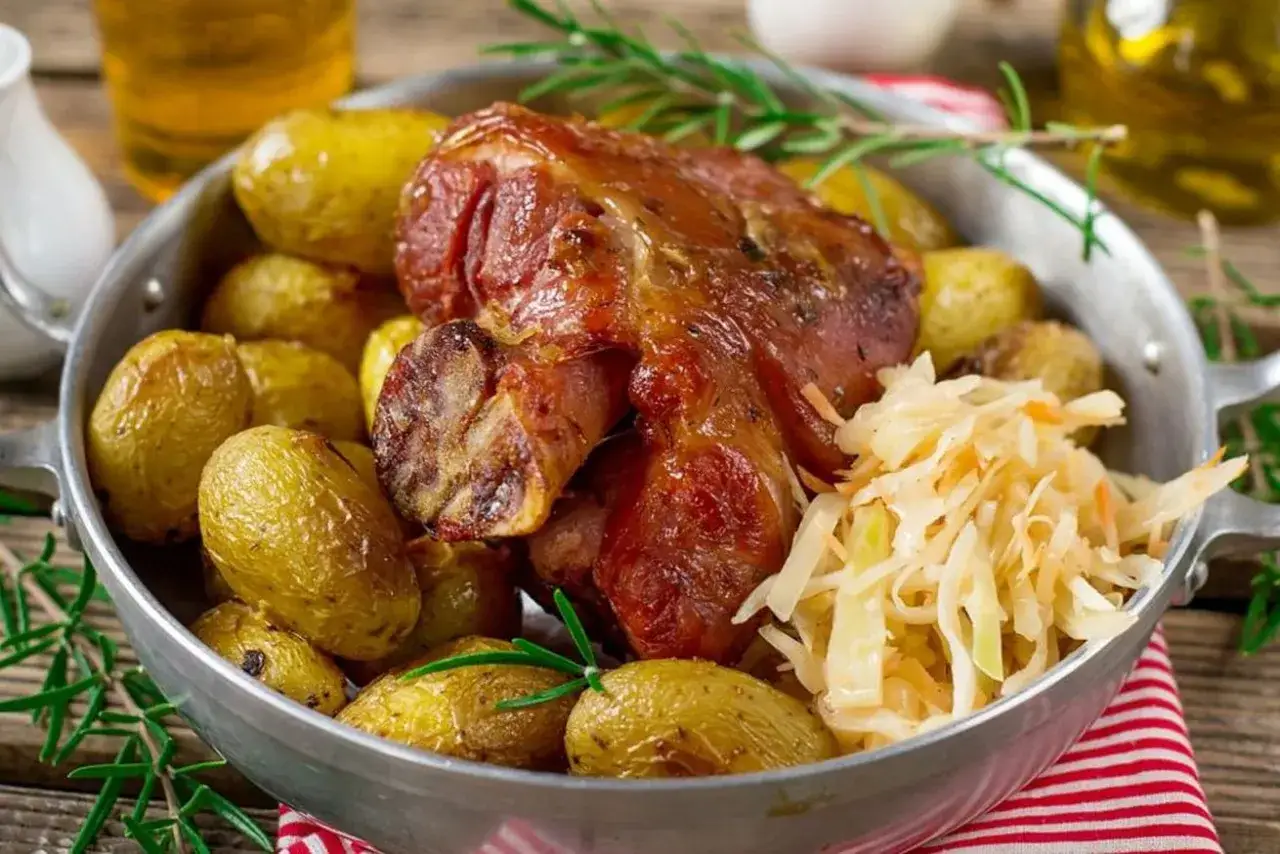 Golonka pieczona z ziemniakami i kapustą kiszoną – klasyka kuchni niemieckiej.