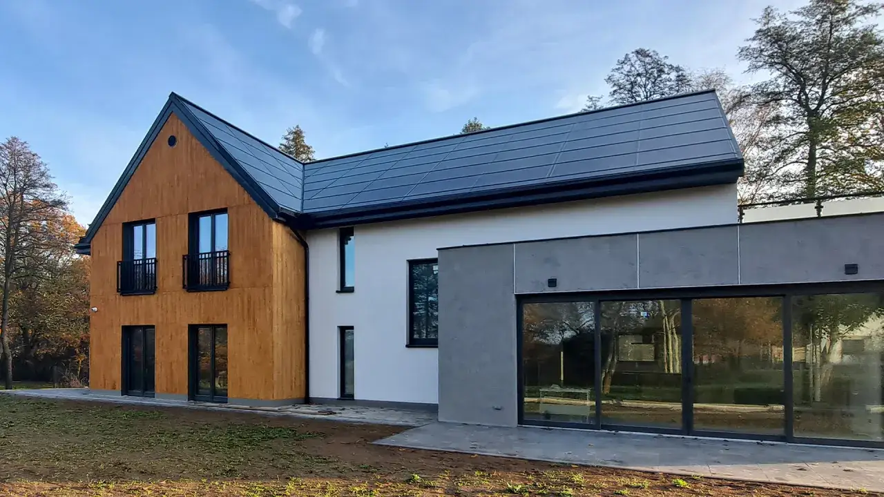 Nowoczesny dom z panelami fotowoltaicznymi na dachu. Zastanawiasz się, ile kosztuje dach solarny?