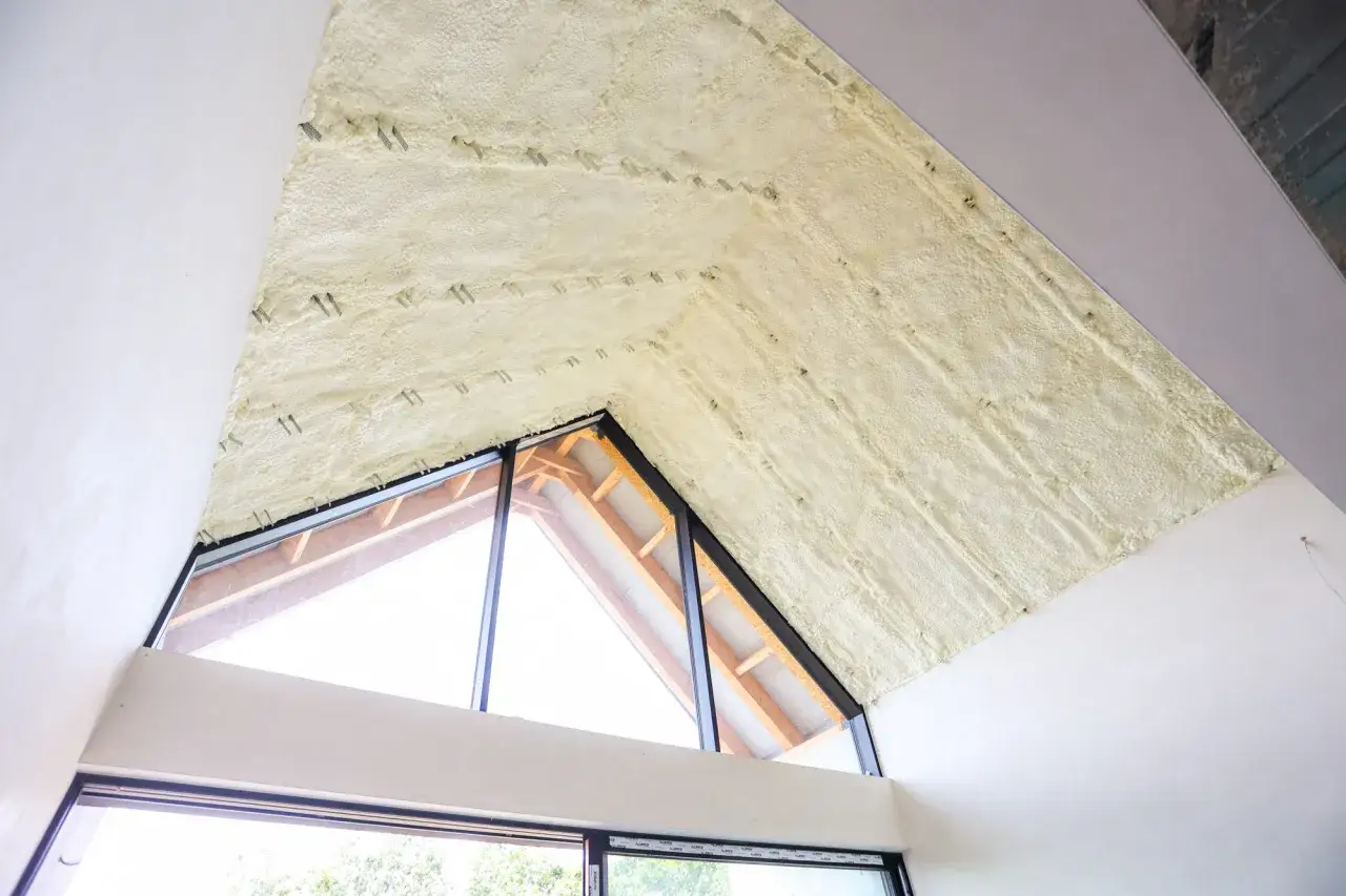 Piana PUR na poddaszu, kt&oacute;ra izoluje lepiej niż wełna. Widoczne drewniane elementy konstrukcji i okna.