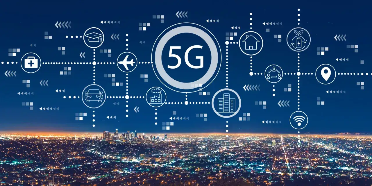 Sieć 5G co to? Ikony symbolizujące edukację, medycynę, transport, przemysł, dom i komunikację łączą się z centralnym symbolem 5G nad nocnym miastem.