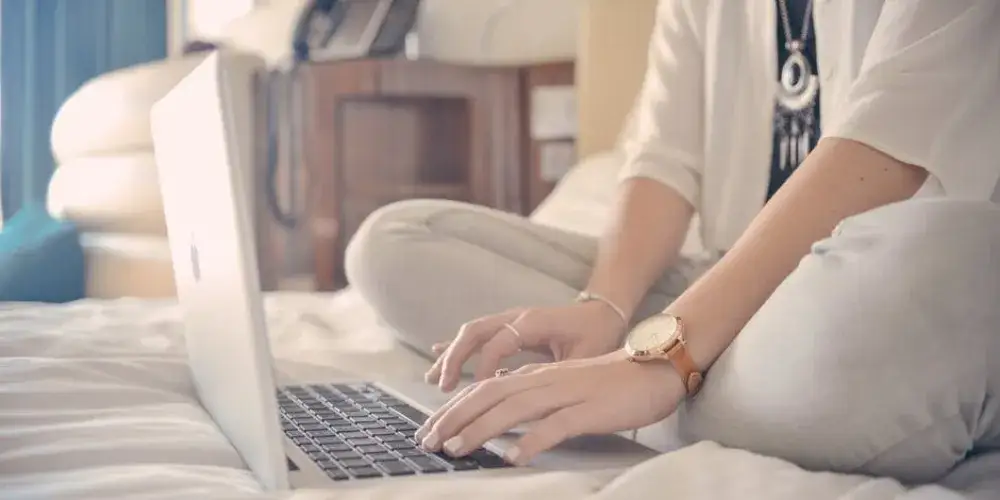 Młoda osoba szukająca stażu na laptopie, przeglądająca oferty pracy