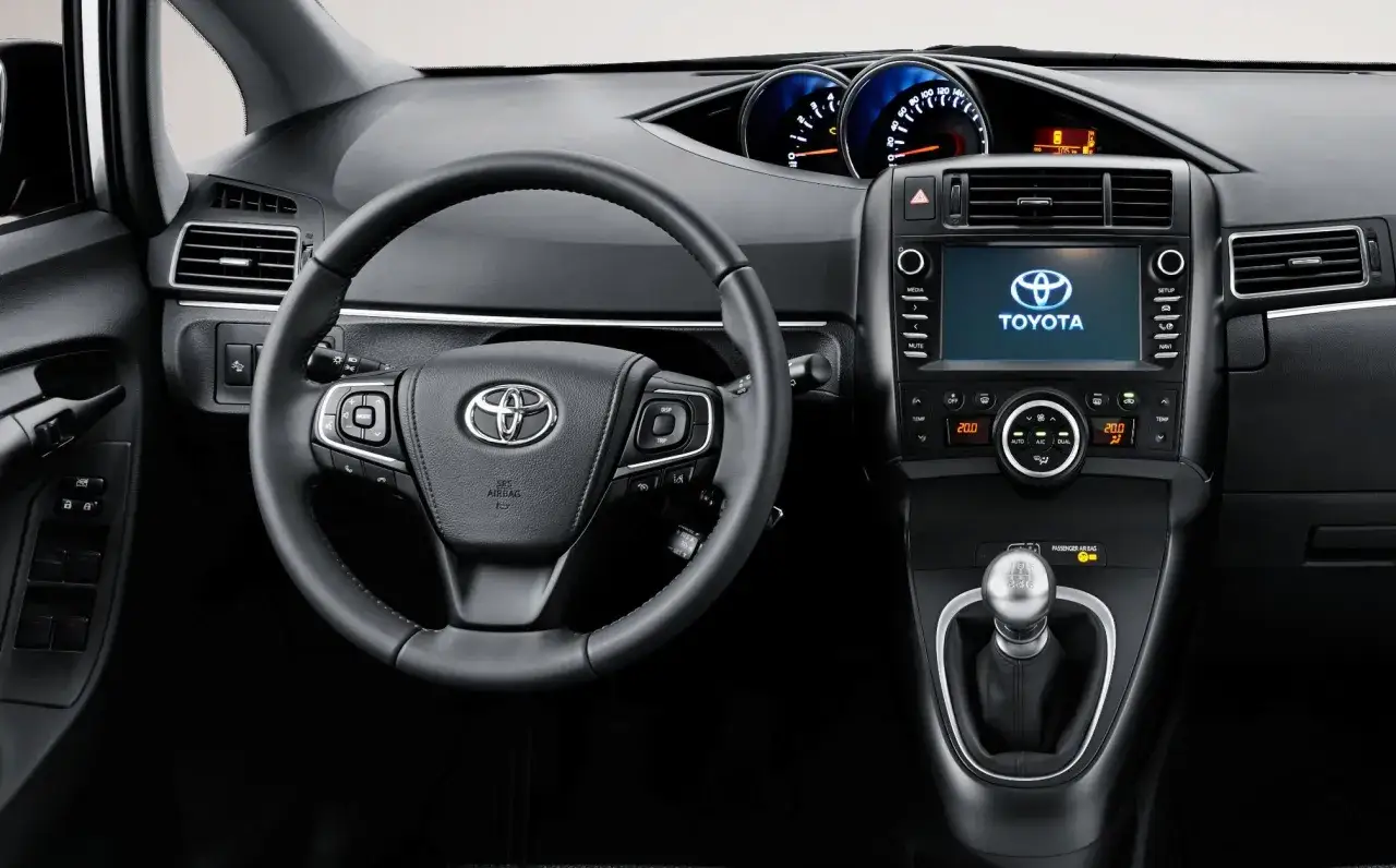 Wnętrze Toyoty Verso: kierownica, ekran multimediów, panel klimatyzacji. Zastanawiasz się nad zakupem? Poznaj wady i zalety tego modelu.
