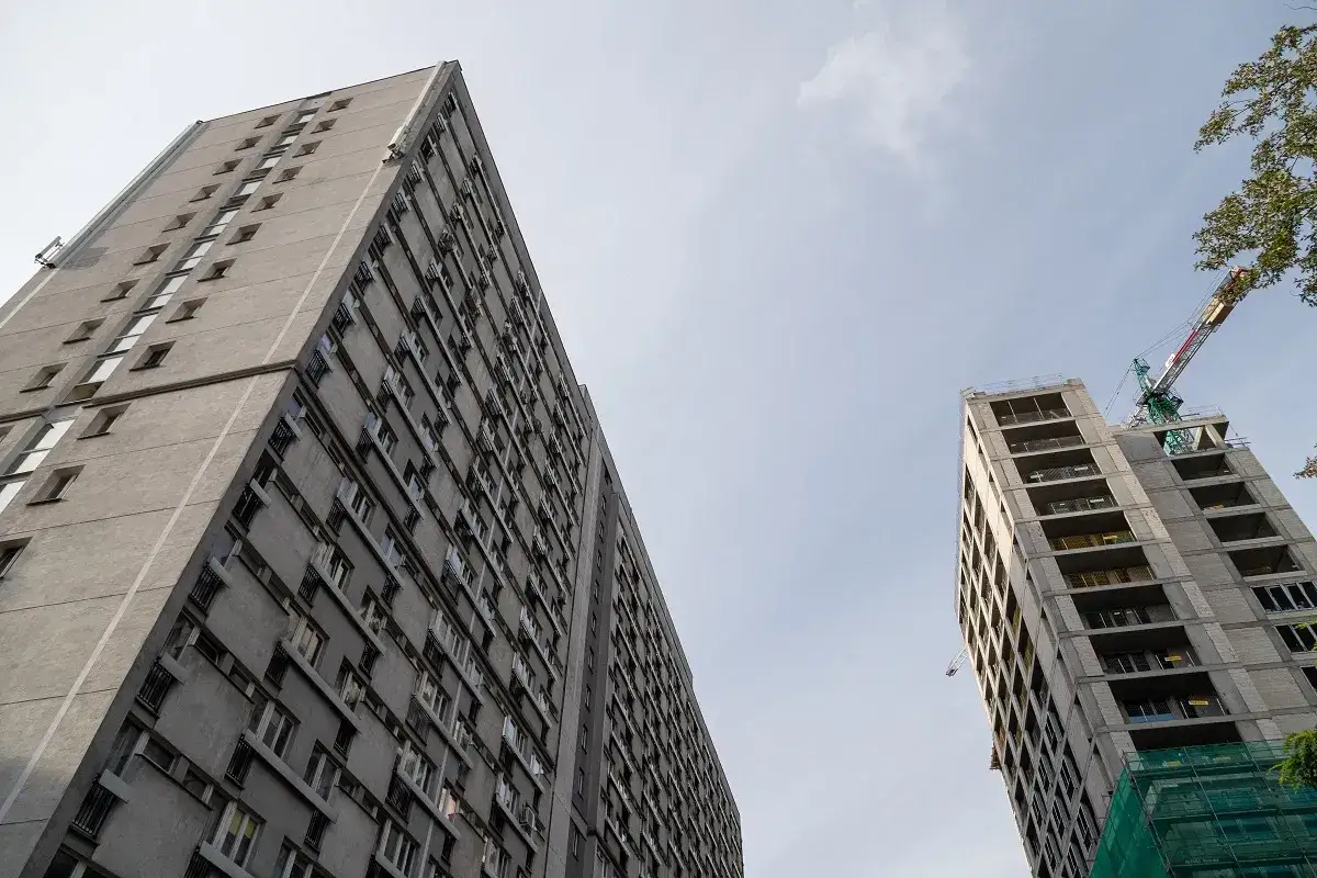 Dwa bloki mieszkalne, jeden starszy, drugi w budowie z dźwigiem. Mieszkanie prawem, nie towarem – potrzeba godnego dachu nad głową dla każdego.