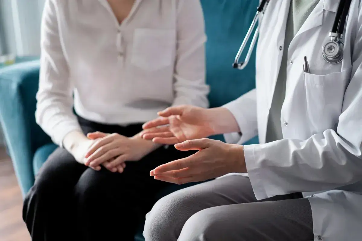 Lekarz w białym kitlu rozmawia z pacjentką. Tylko lekarz psychiatra może wypisać receptę na leki psychotropowe.