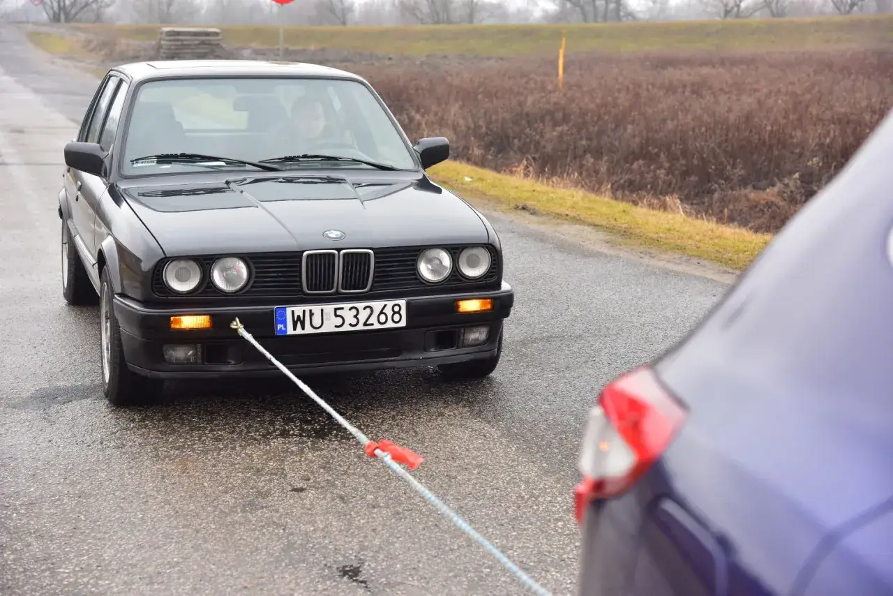 samochód holowany z włączonymi światłami awaryjnymi błąd