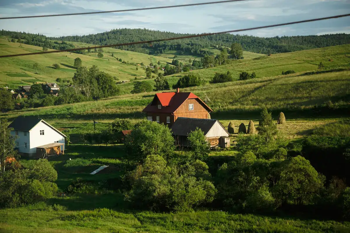 Zielone wzgórza, domy i stogi siana. Kto płaci podatek od dzierżawy gruntu w takiej scenerii?