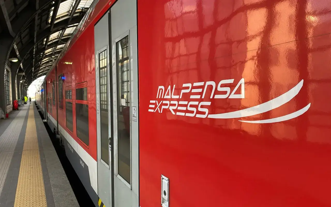 Czerwony pociąg Malpensa Express na peronie. Szybki transport na lotnisko Mediolan Malpensa.