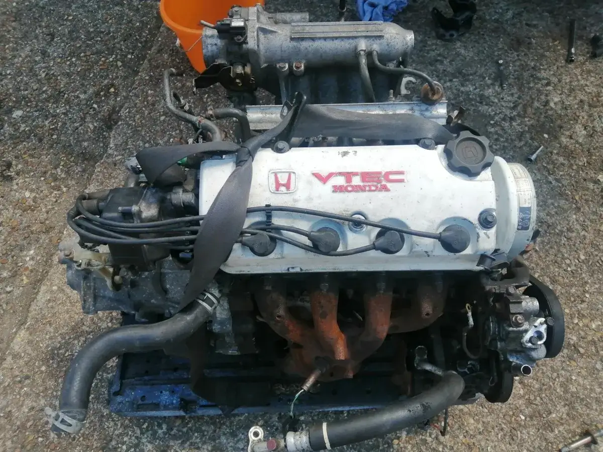 Silnik od Esioka, Honda VTEC, gotowy do montażu lub regeneracji. Widoczne przewody, kolektor i elementy osprzętu.