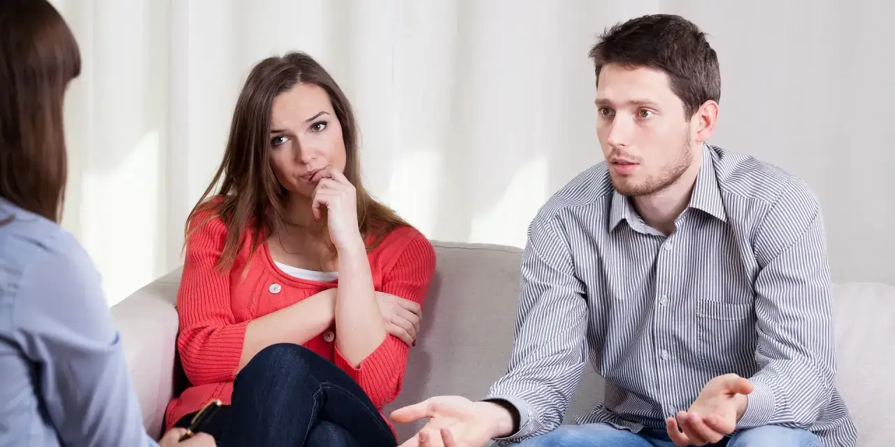 Para zmagająca się z problemami, siedząca na kanapie u terapeuty. Czasem małżeństwo to morderstwo dla uczuć.