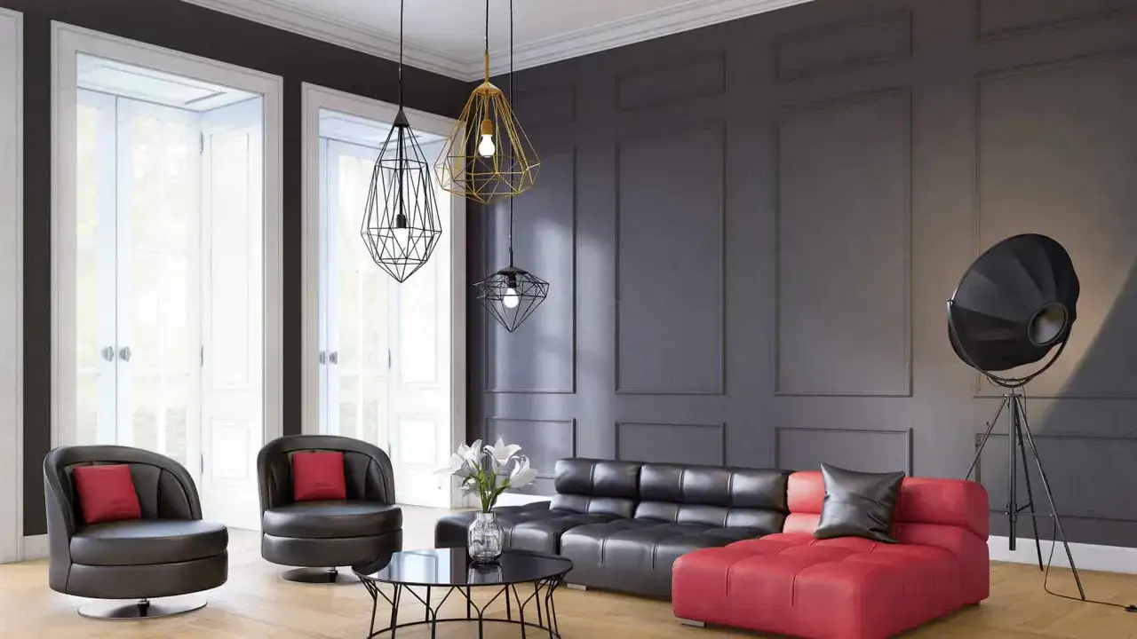 Nowoczesny salon z czarną kanapą i czerwoną sofą. Nad nimi wisi ozdobny pasek pod sufitem z lampami.