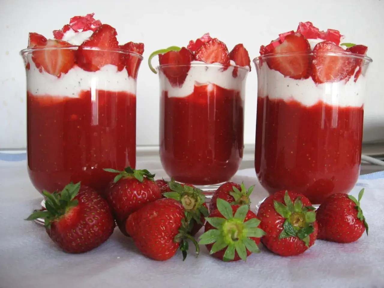 Pyszne desery z truskawek w szklankach, z bitą śmietaną i kawałkami owoców. Idealne, gdy zastanawiasz się, co zrobić z truskawek.
