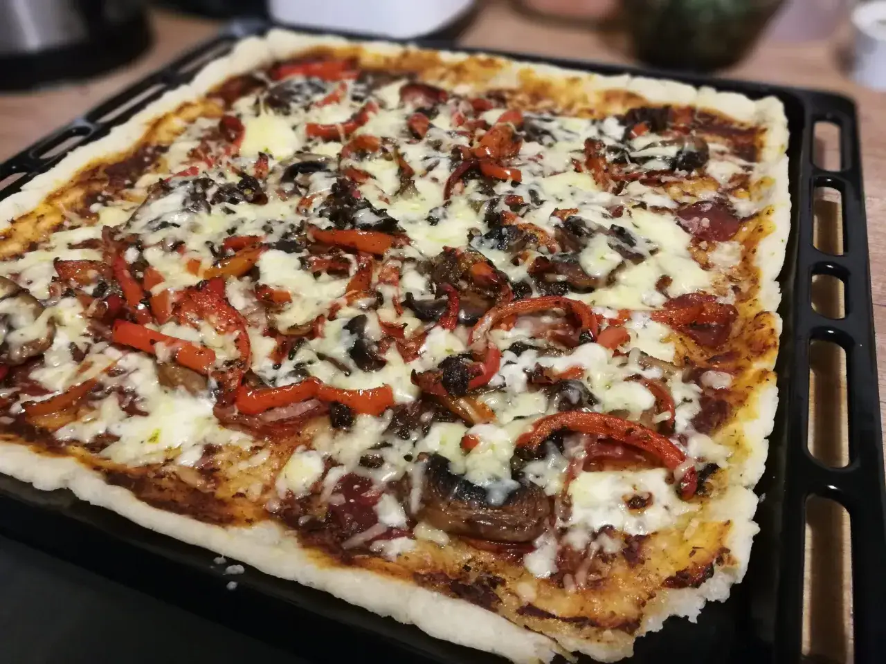 Domowa pizza bezglutenowa z pieczarkami i papryką, idealna na szybki obiad.