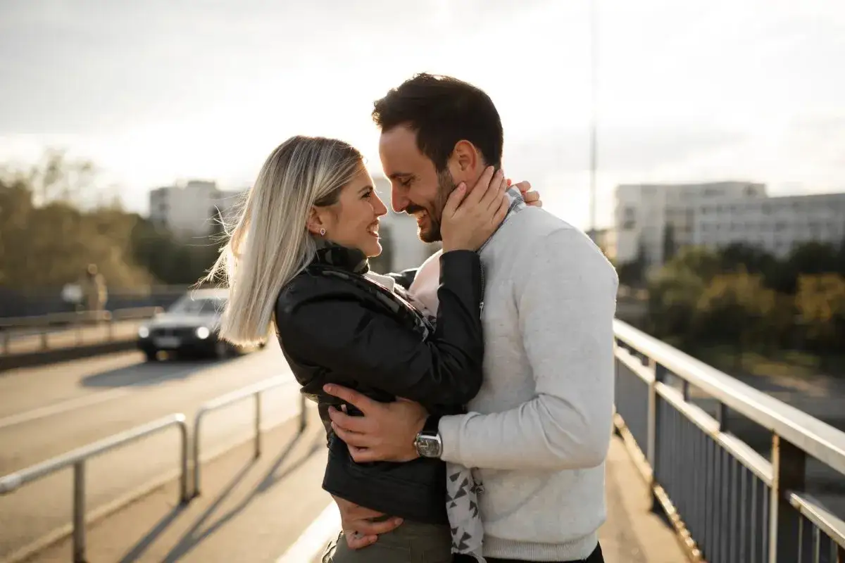 Szczęśliwa para, kt&oacute;ra odnalazła miłość po rozstaniu, przytulająca się na moście.
