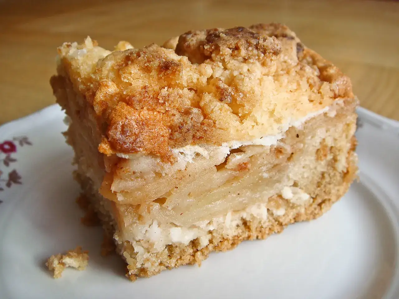 Kawałek pysznej szarlotki z kruszonką, idealny przykład, jak się robi szarlotkę.