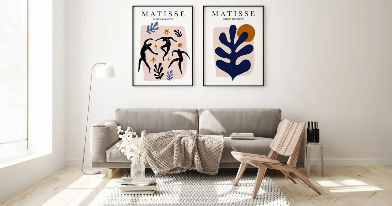 Dwa plakaty w stylu Matisse'a, przedstawiające tańczące sylwetki i abstrakcyjne kształty, tworzą artystyczny akcent nad sofą. Idealne plakaty DIY do nowoczesnego wnętrza.