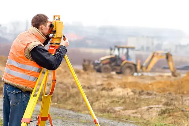 Geodeta przy pracy z tachimetrem na placu budowy