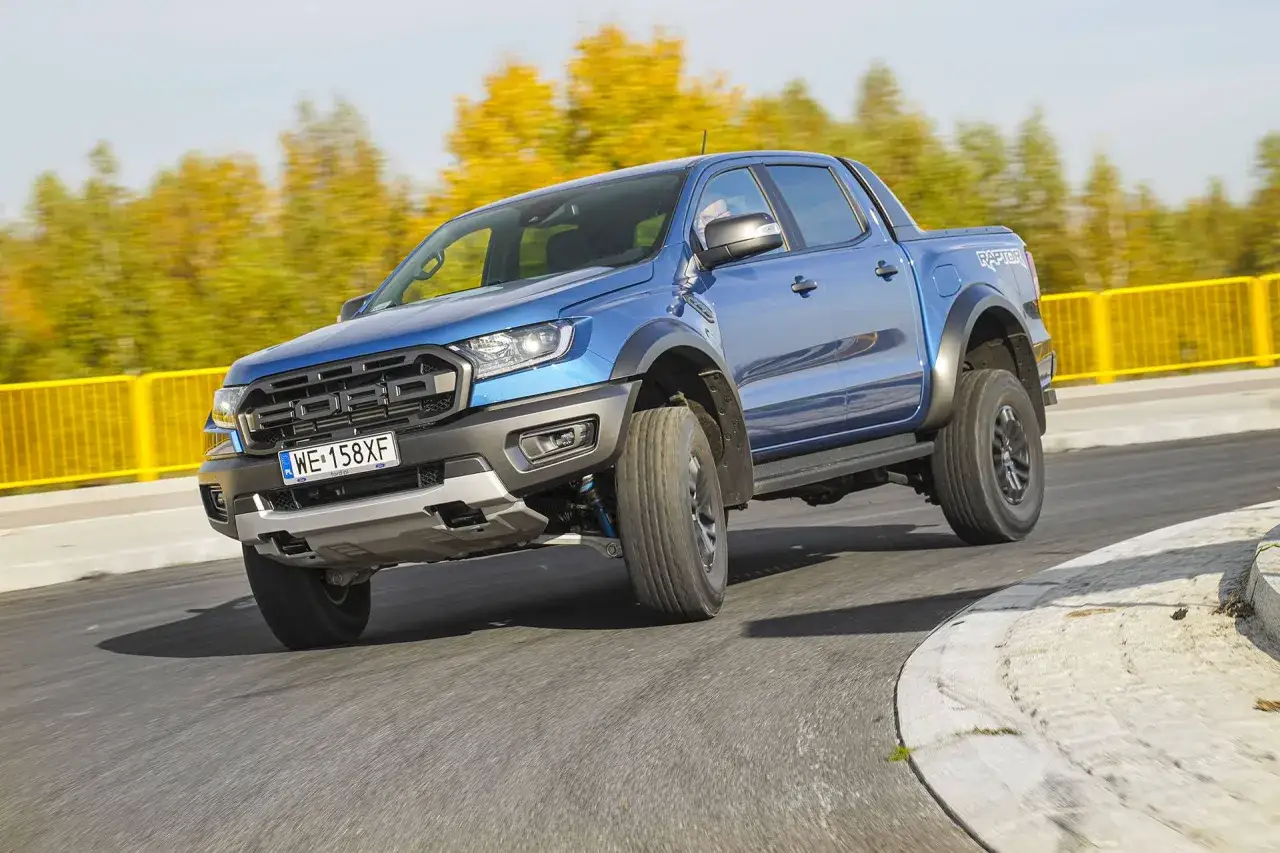 Niebieski Ford Raptor na zakręcie. Zastanawiasz się nad jego spalaniem? Ten potężny pickup robi wrażenie.