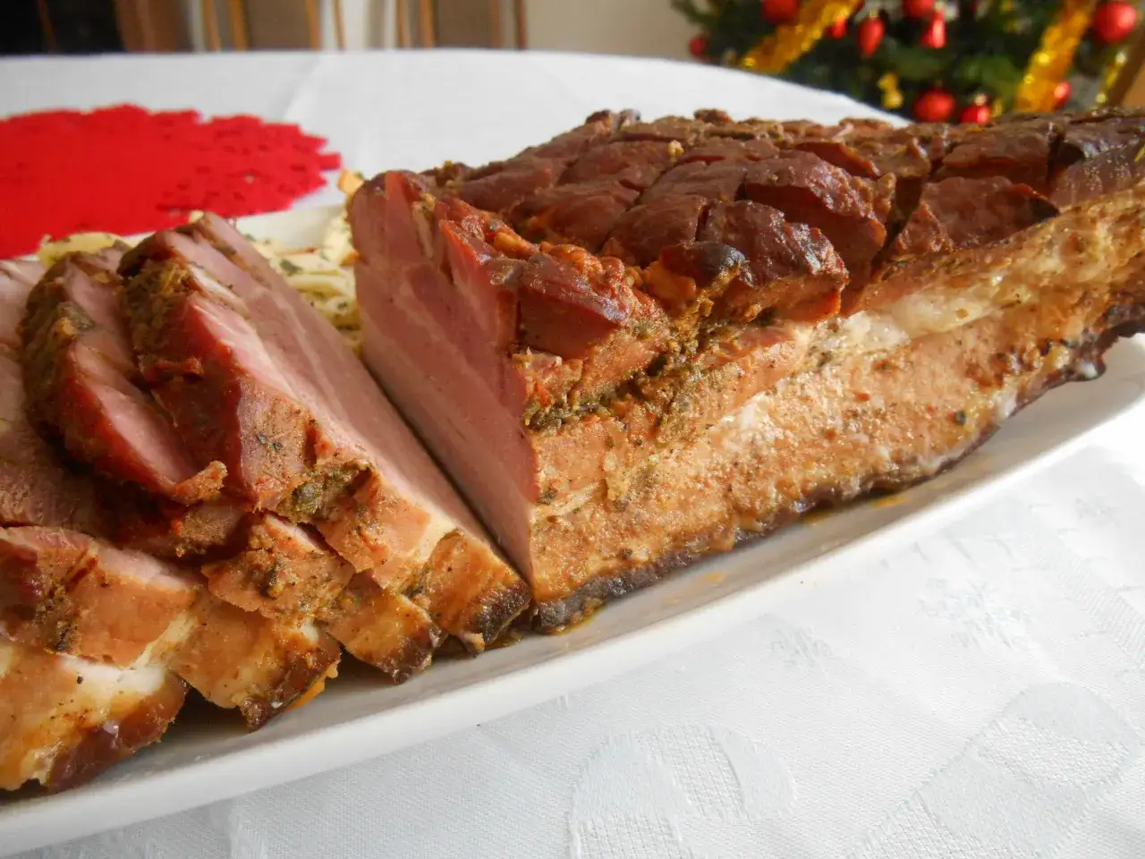 Pyszny boczek pieczony w rękawie, soczysty i aromatyczny, pokrojony w plastry. Idealny na świąteczny st&oacute;ł.