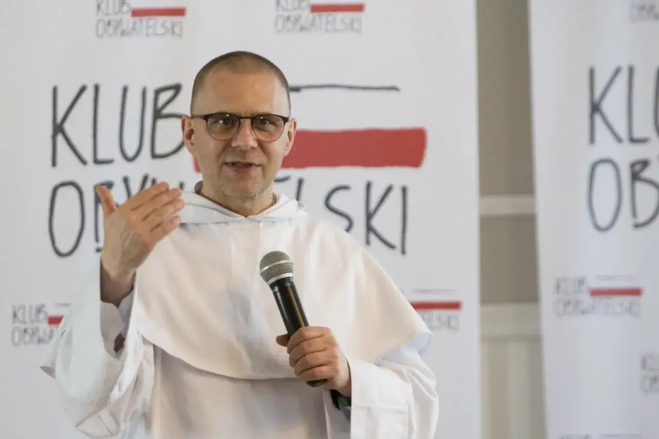 Ksiądz w habicie z mikrofonem, przemawia. Może to jego ostatnie kazanie, kiedy ksiądz idzie na emeryturę.