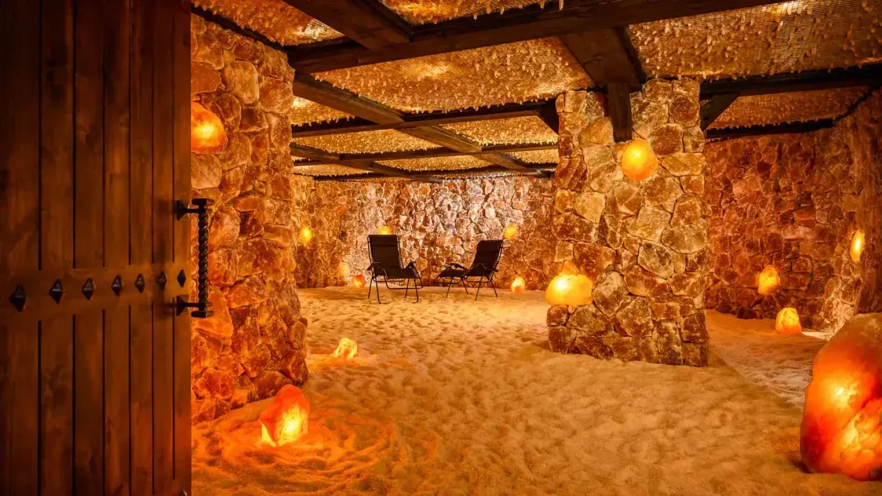 Wnętrze groty solnej z kamiennymi ścianami, solną podłogą i lampami. Dowiedz się, jak się ubrać do groty solnej, by czuć się komfortowo.