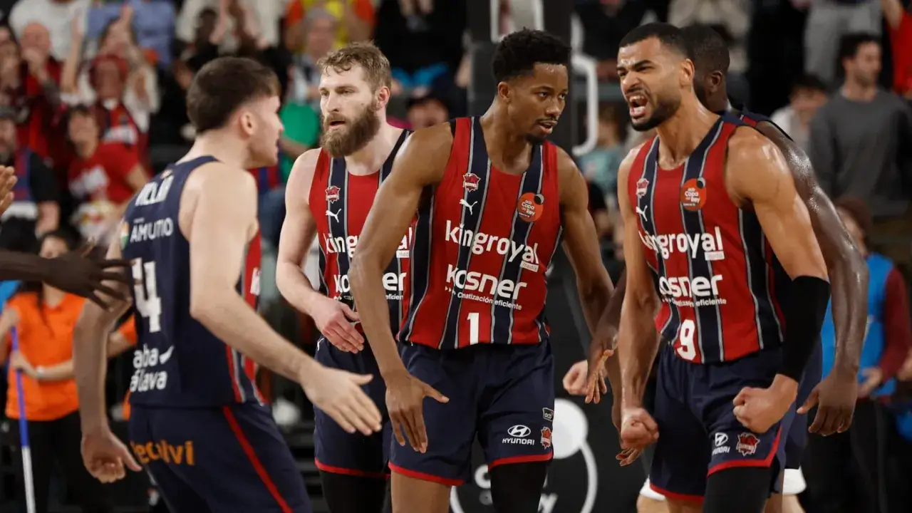 Jugadores celebran, quizás tras ganar la Copa del Rey de baloncesto. Sus camisetas rojas y azules lucen el logo de 