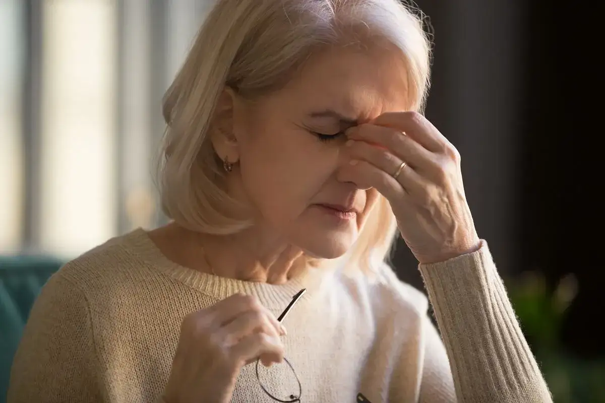 osoba zaniepokojona trzymająca się za głowę
