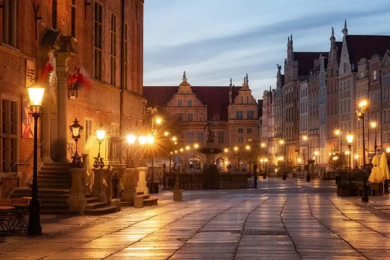 Wieczorny spacer po Długim Targu w Gdańsku. Urokliwe kamienice i fontanna Neptuna tworzą niepowtarzalny klimat, idealny na odkrywanie gdańsk atrakcje turystyczne.
