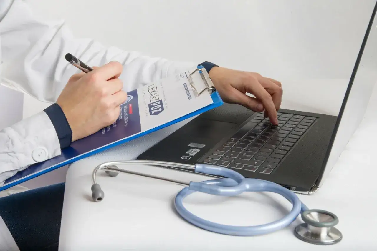 Lekarz z notatkami i stetoskopem przy laptopie. Czy pracodawca może kontrolować pracownika na L4?
