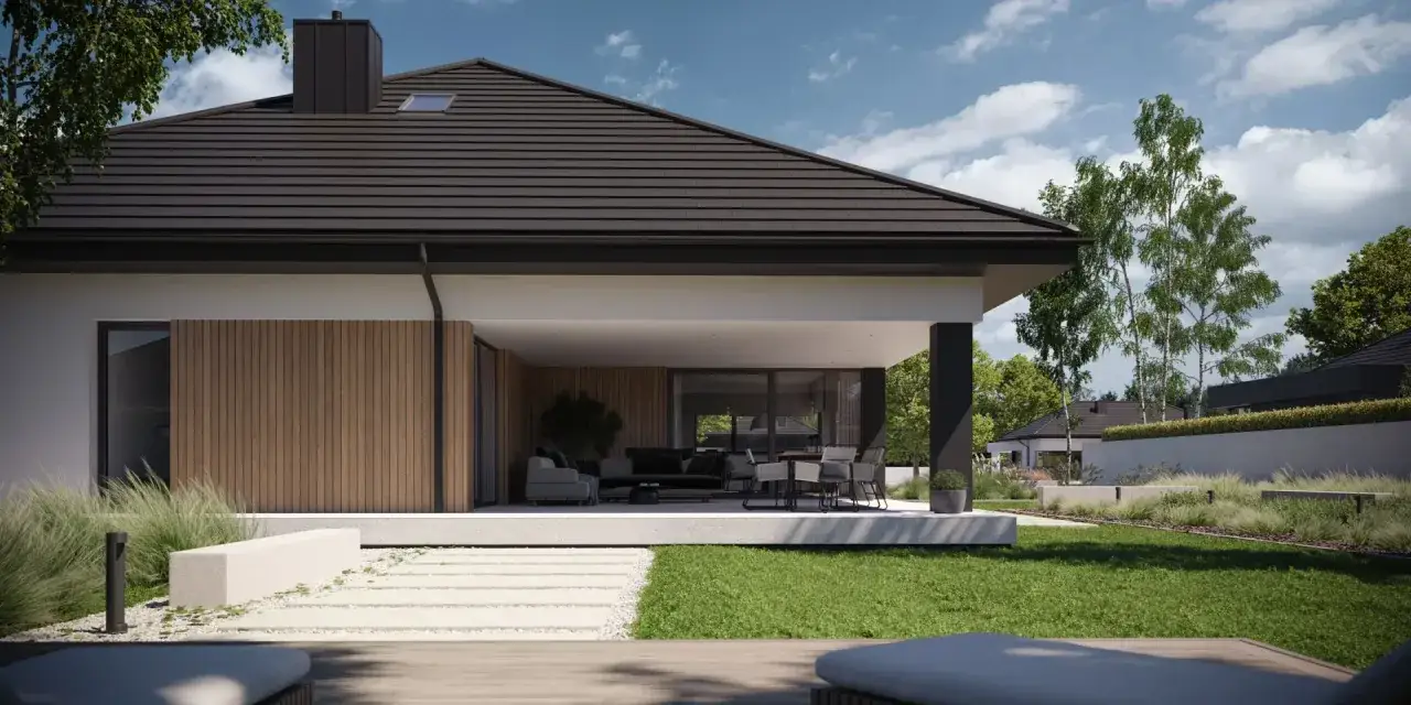 Nowoczesny dom w kształcie litery L z przeszklonym tarasem i wygodną strefą wypoczynkową na zewnątrz.