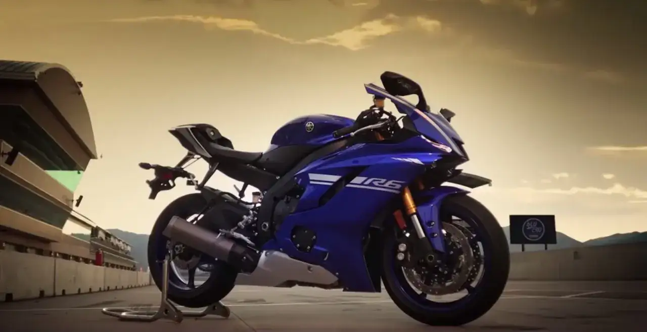 Niebieski motocykl Yamaha YZF R6 na torze wyścigowym, gotowy do akcji.