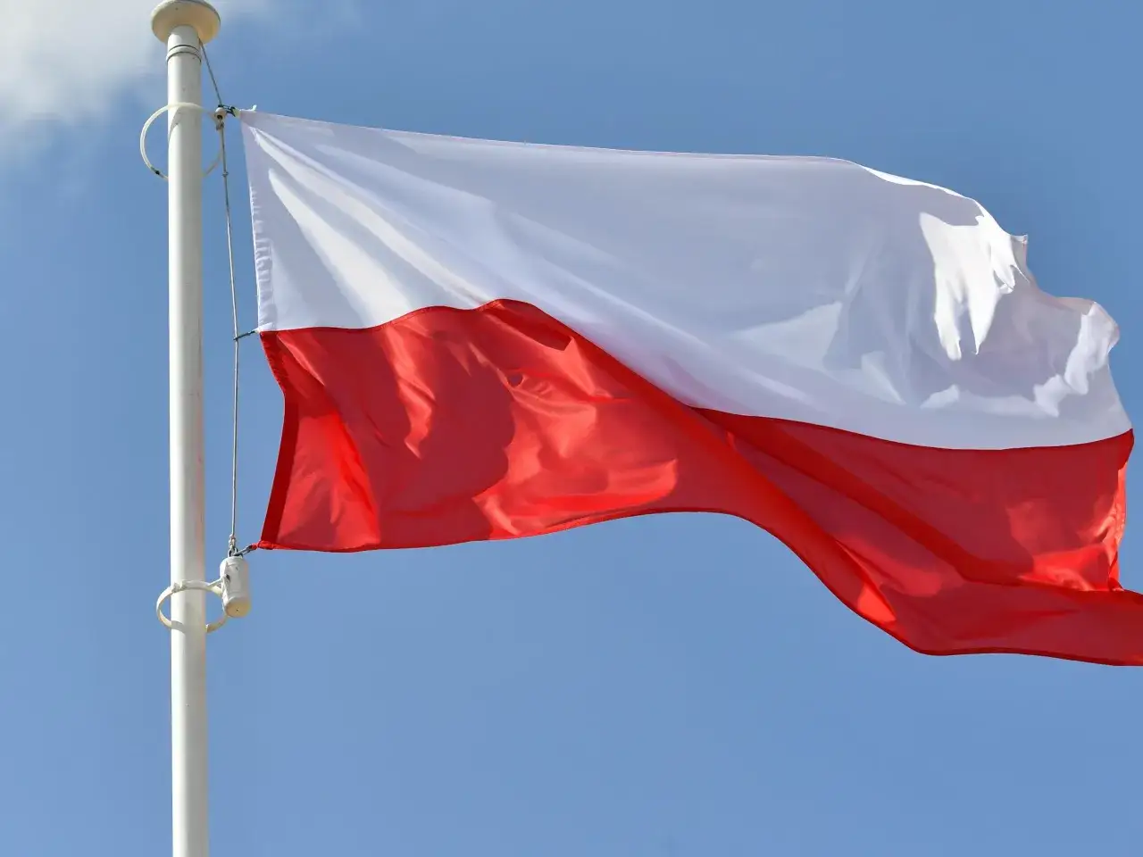 R&oacute;żnica między Poland a Polish zobrazowana flagą i książką do języka polskiego