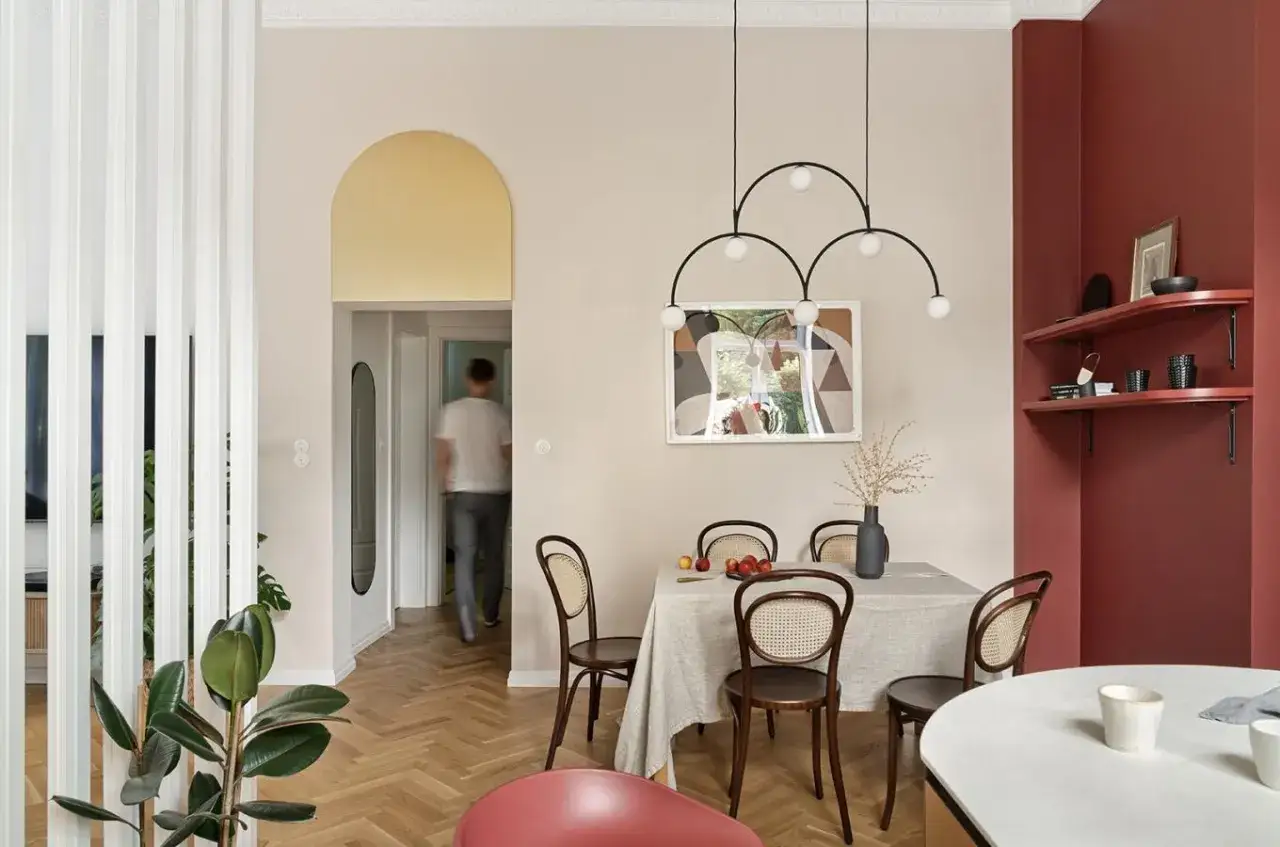 Elegancki salon z jadalnią, gdzie łuk nad przejściem dodaje uroku. Wnętrze zdobią stylowe meble i nowoczesne oświetlenie.