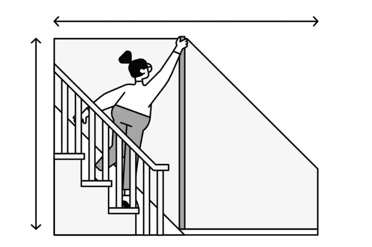 Kobieta mierzy wysokość schod&oacute;w, by dowiedzieć się, jak obliczyć metry kwadratowe ściany pod nimi.