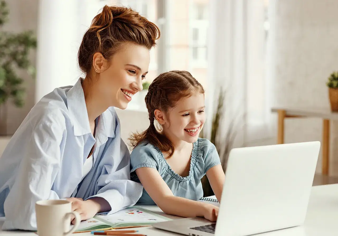 Mama i córka cieszą się z nauczania domowego podstawówka. Razem odkrywają świat przez ekran laptopa, uśmiechnięte i zaangażowane.