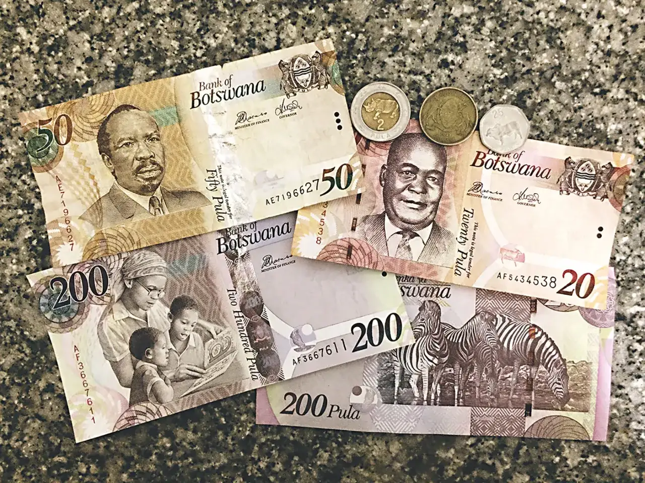 Botswana waluta: banknoty 200, 50 i 20 pula oraz monety. Na banknotach portrety, rodzina z dziećmi i zebry.