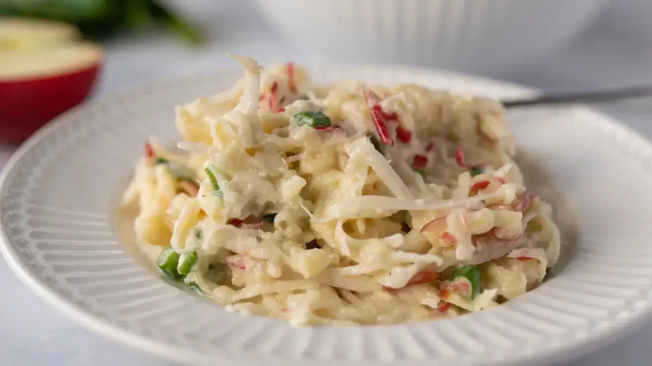 Pyszna sur&oacute;wka z selera z jabłkiem i majonezem, podana na białym talerzu.
