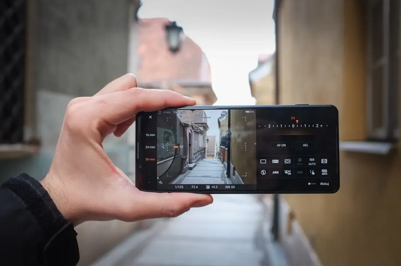 Dłoń trzyma smartfon Sony Xperia Pro-I Mark II, kadrując wąską uliczkę.