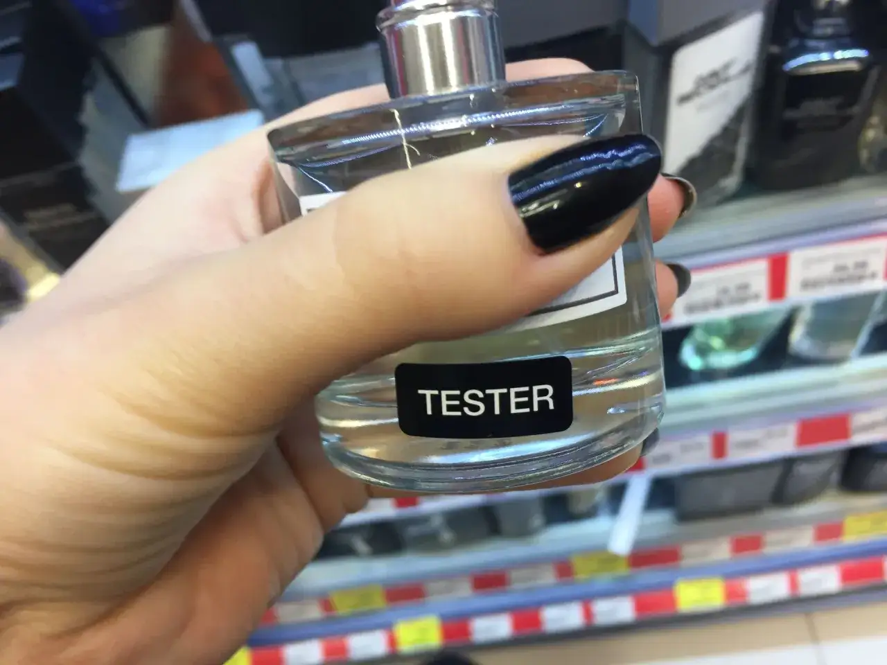Ręka trzyma tester perfum. Szukasz, gdzie kupić oryginalne testery perfum? Warto zajrzeć do drogerii.
