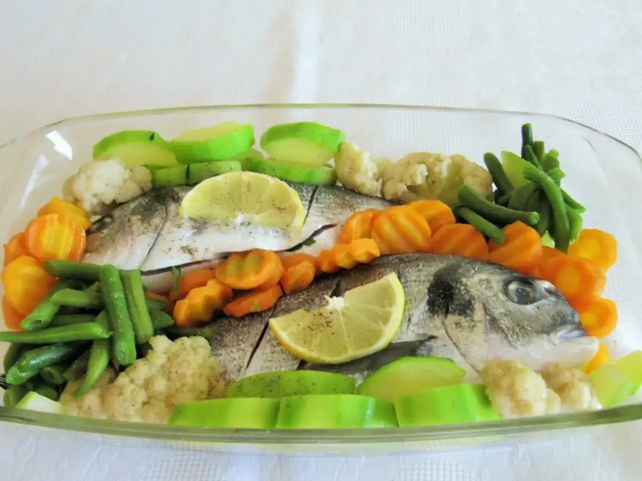 Dorada z piekarnika z marchewką, fasolką szparagową, kalafiorem i plasterkami cytryny.