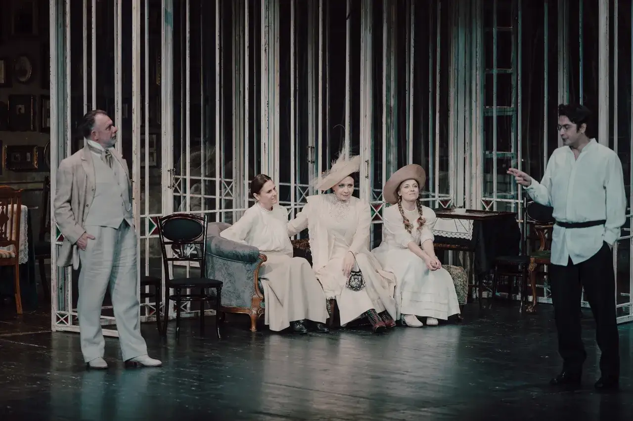 Aktorzy na scenie, w strojach z epoki, tworzą atmosferę 