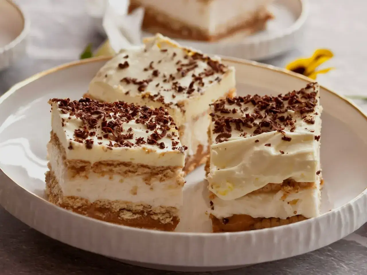 Tanie ciasto bez pieczenia z herbatnikami, kremem i czekoladową posypką. Idealne na szybki deser.