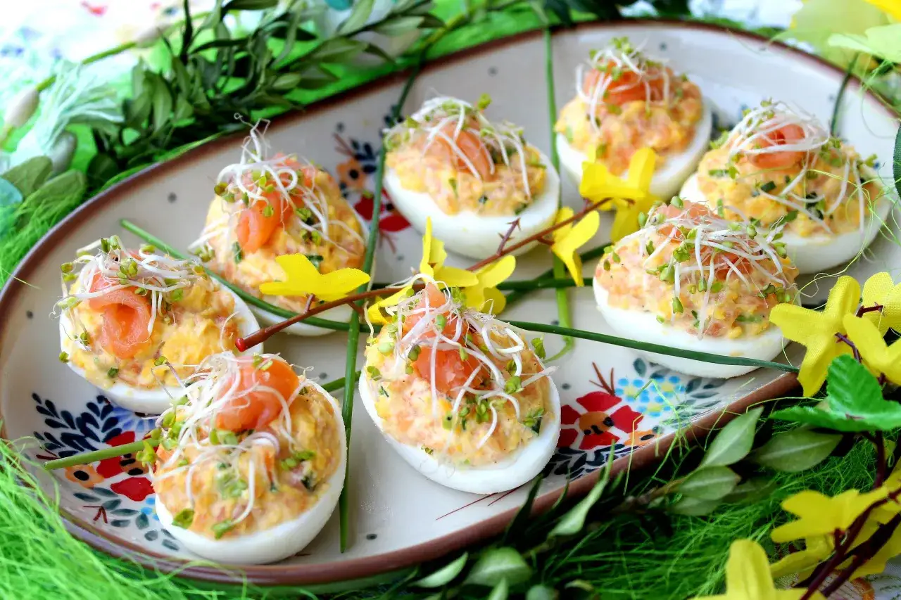 Pyszne jajka faszerowane łososiem, udekorowane kiełkami i ż&oacute;łtymi kwiatami. Idealna przekąska na wielkanocny st&oacute;ł.
