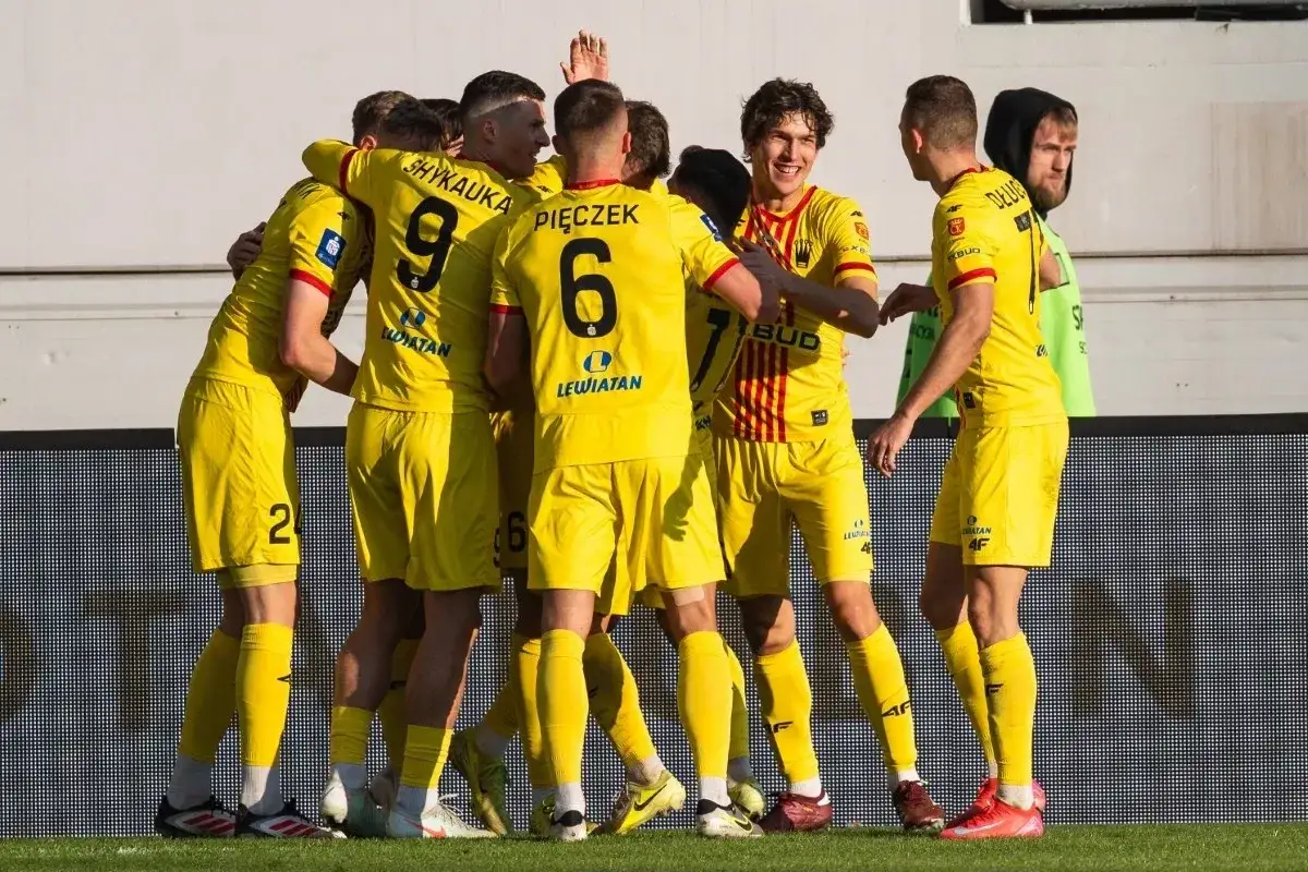 Radosna feta zawodników Korony Kielce po strzelonym golu. Piłkarze w żółtych strojach świętują razem.