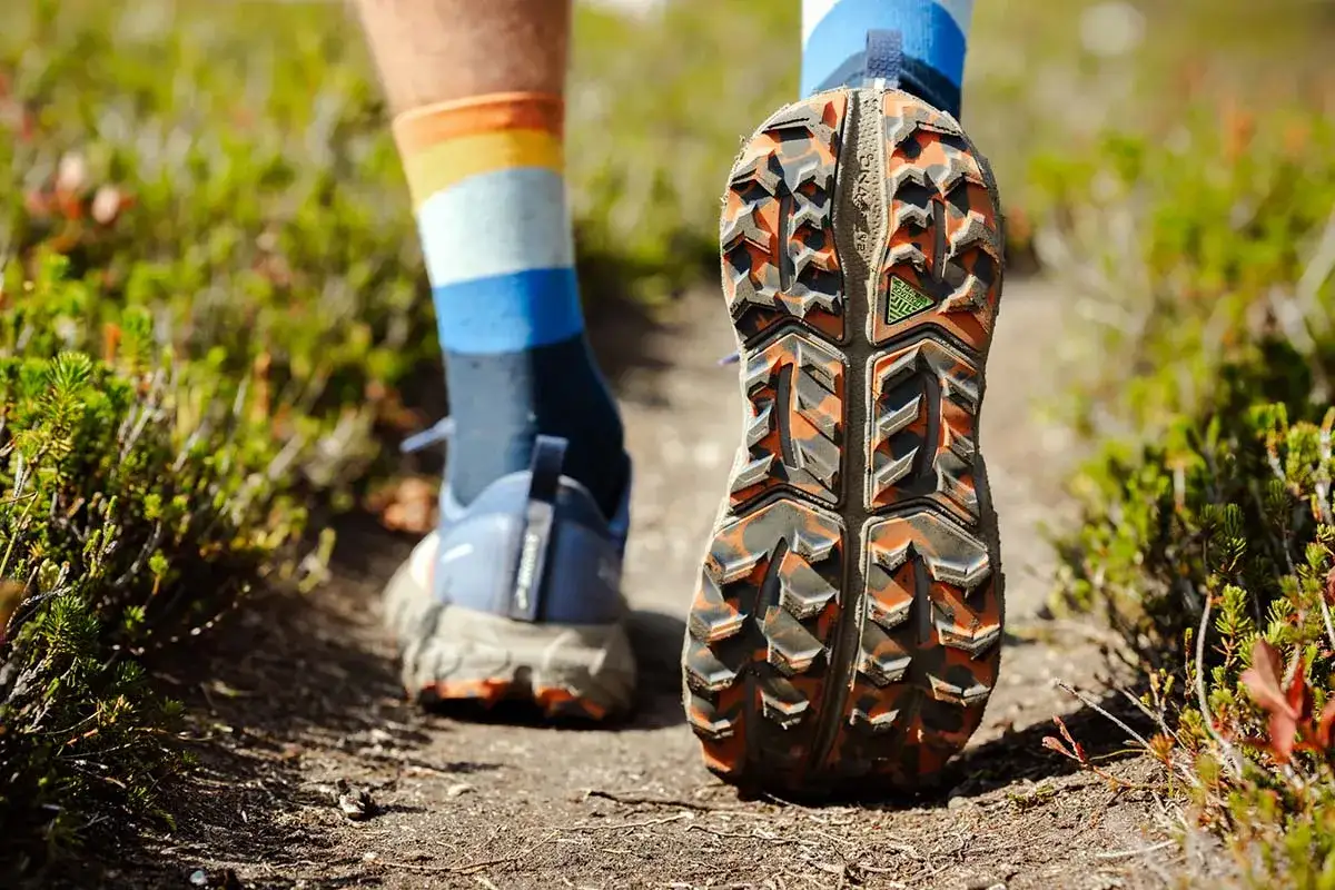 Buty trailowe co to? Zobacz podeszwę z agresywnym bieżnikiem, gotową na terenowe wyzwania. Kolorowe skarpety dodają stylu.