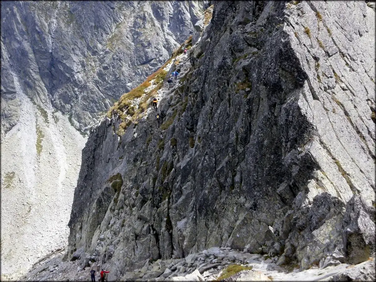 Turyści na skalistej grani, gdzie powstawały szlaki w Tatrach. Wspinaczka po stromych zboczach.