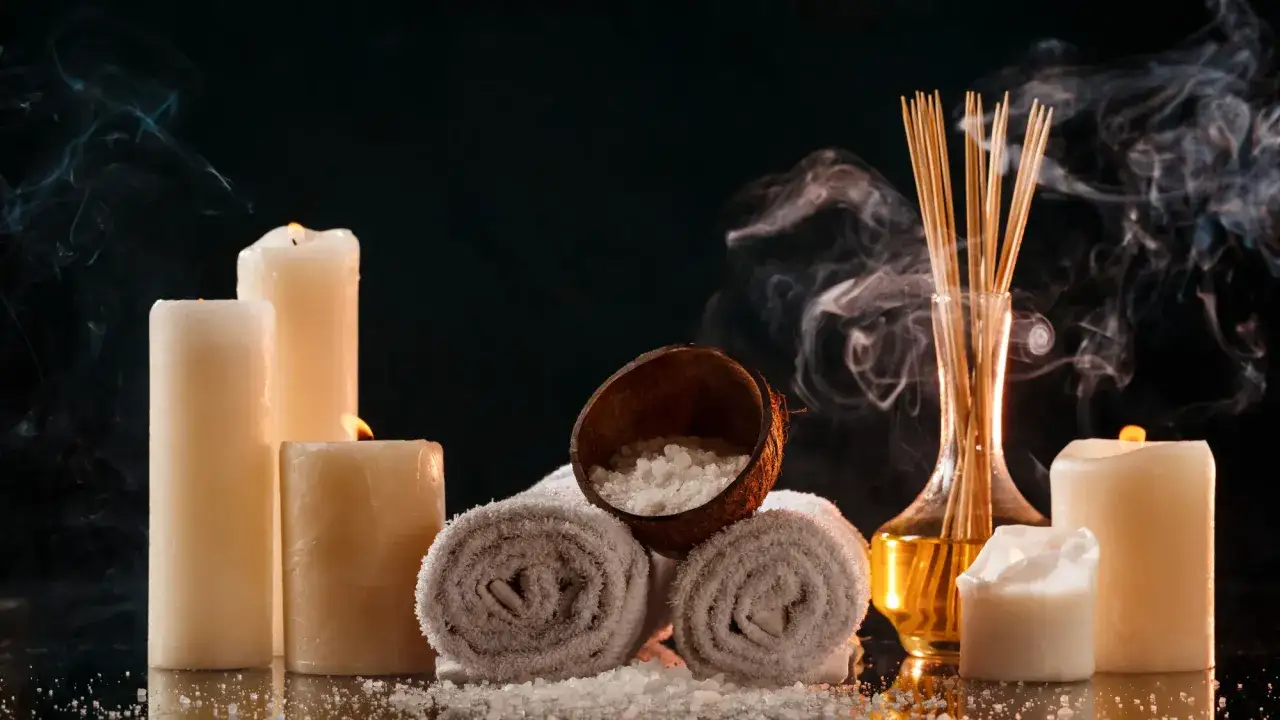 Pachnące świece, olejki i sole tworzą atmosferę domowego spa. Dymek unosi się, zapraszając do relaksu.