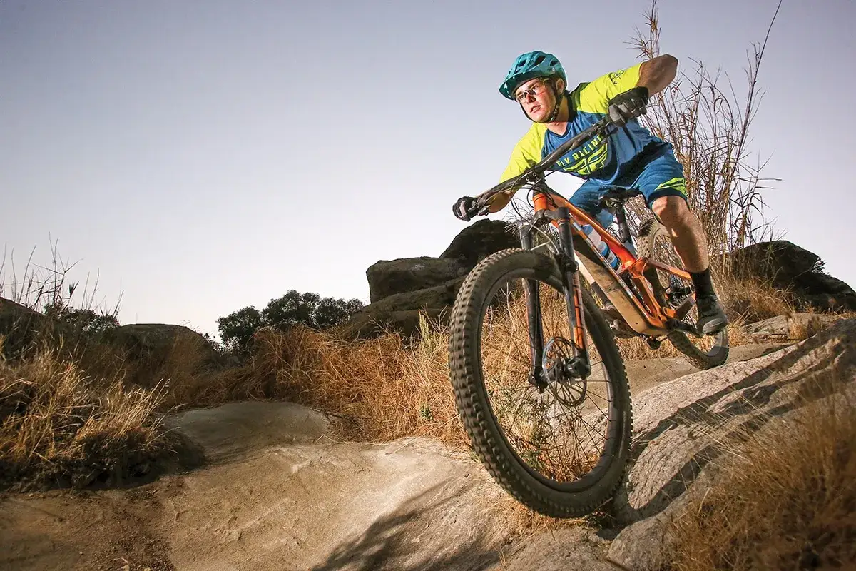 Kolarz w kasku i okularach zjeżdża rowerem enduro po kamienistym szlaku. To właśnie jest **enduro co to** za sport!