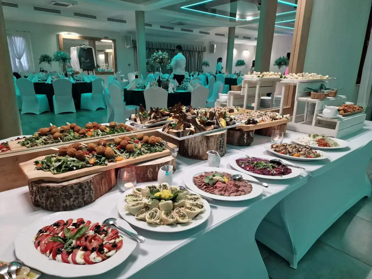 Elegancki bankiet w rancho pod bocianem. Stoły uginają się od wykwintnych potraw: carpaccio, sałatek, ryb i przekąsek.