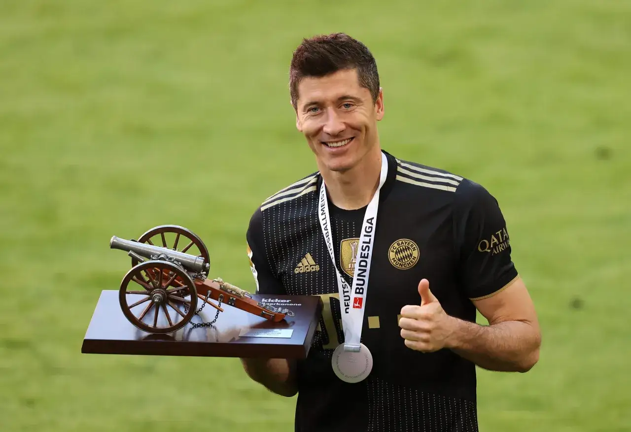 Robert Lewandowski, najlepszy strzelec Bundesligi, z pucharem w kształcie armaty i medalem.